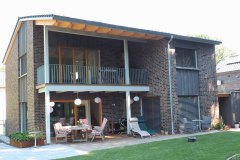 Gartenansicht mit überdachter Terrasse und Balkon