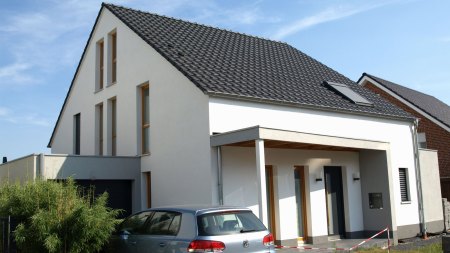 Einfamilienhaus in Münster mit weißer Putzfassade und überdachtem Eingang