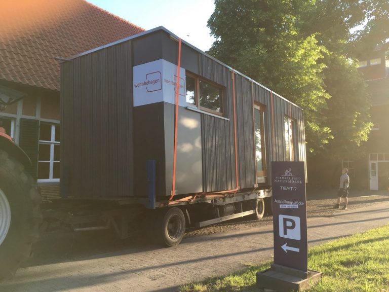 Ein Tiny House wir auf einen Traktor-Anhänger transportiert.