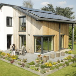 Ein Plus-Energiehaus Neubau von wohnbehagen mit weißer und hölzener Fassade auf grünem Grundstück.