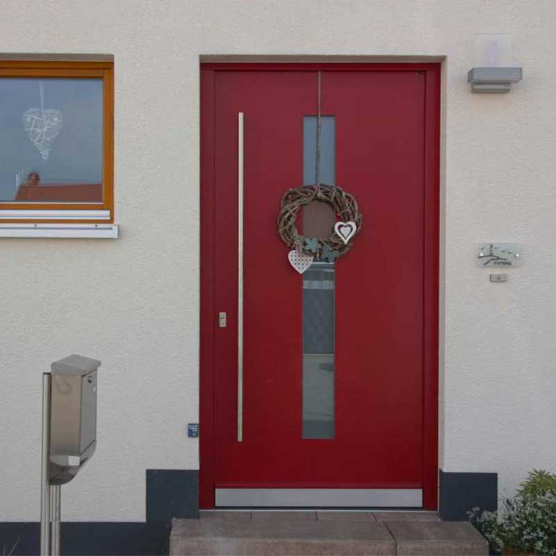 Rote Haustür des Einfamilienhauses Effi 55 und einem vor der Tür platzierten silbernen Briefkasten.
