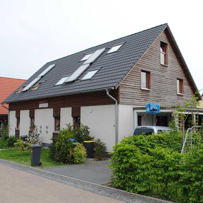 Ein Doppelhaus mit Effi 40 und teils weißer, teils hölzener Fassade von Wohnbehagen.