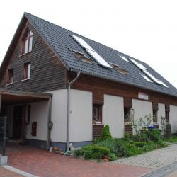 Seitenansicht von einem Doppelhaus mit Effi 40 und einem Carport an der rechten Seite.