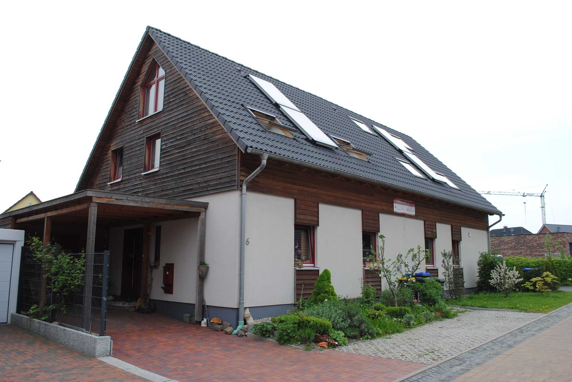 Seitenansicht von einem Doppelhaus mit Effi 40 und einem Carport an der rechten Seite.