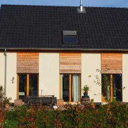 Rückansicht aus dem Garten mit Blick auf die Terrasse des Einfamilienhauses EFFI 70 in Hochmoor.