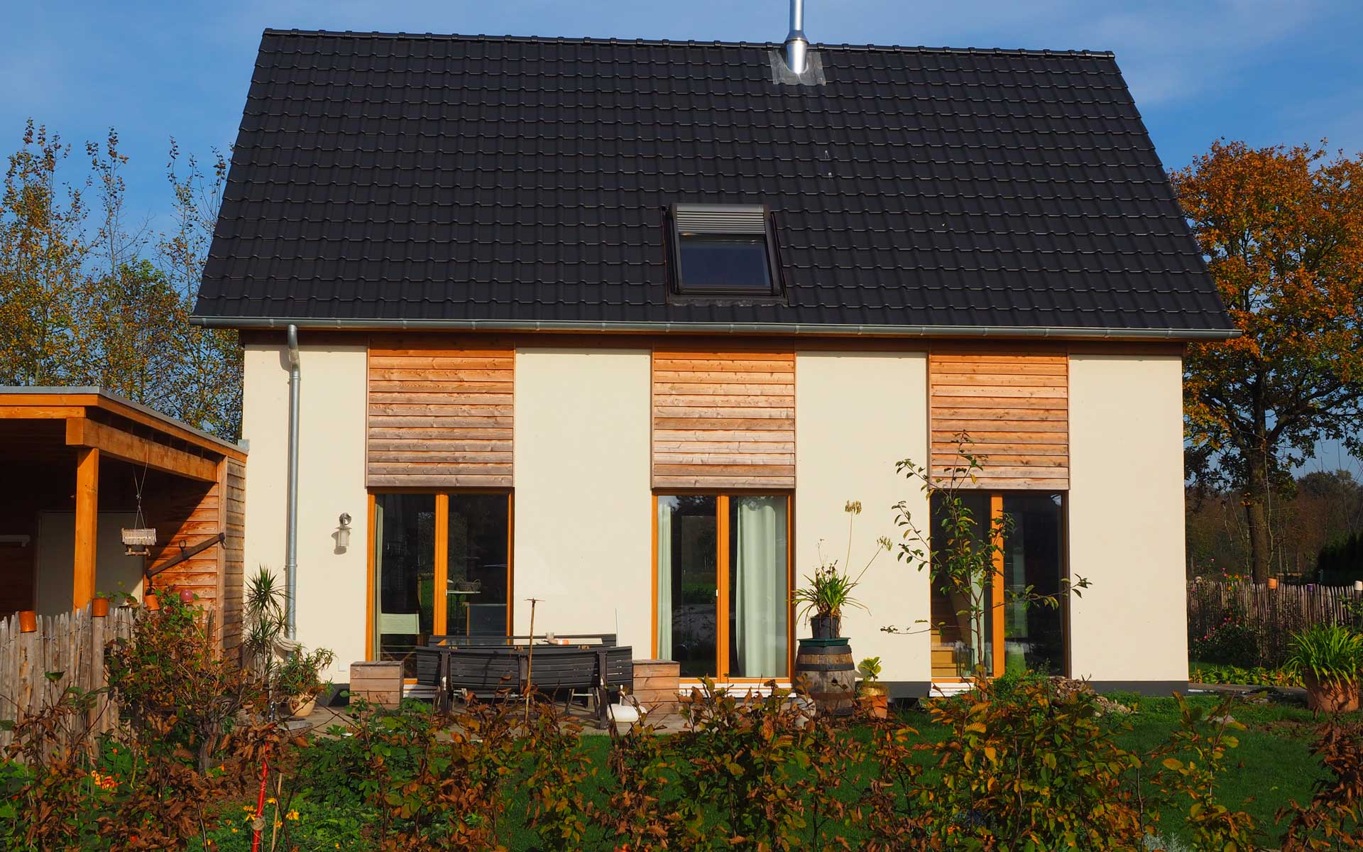 Rückansicht aus dem Garten mit Blick auf die Terrasse des Einfamilienhauses EFFI 70 in Hochmoor.