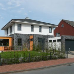 Ein Wohnhaus im Villenstil mit einer Kombination aus Klinker- und Fassadenputz und einem Walmdach.