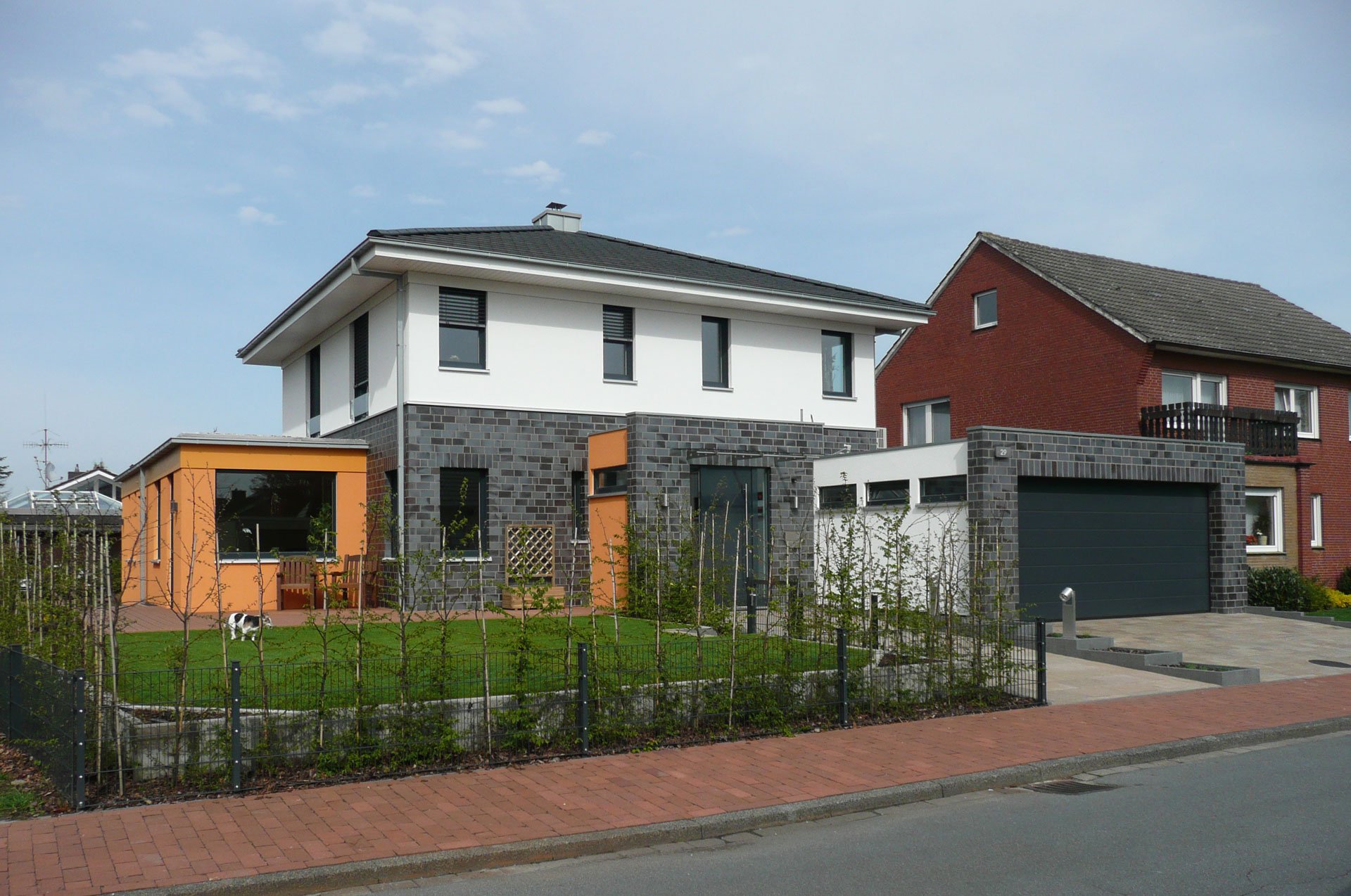 Ein Wohnhaus im Villenstil mit einer Kombination aus Klinker- und Fassadenputz und einem Walmdach.