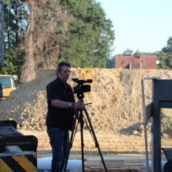 Der Kameramann steht draußen auf der Baustelle.