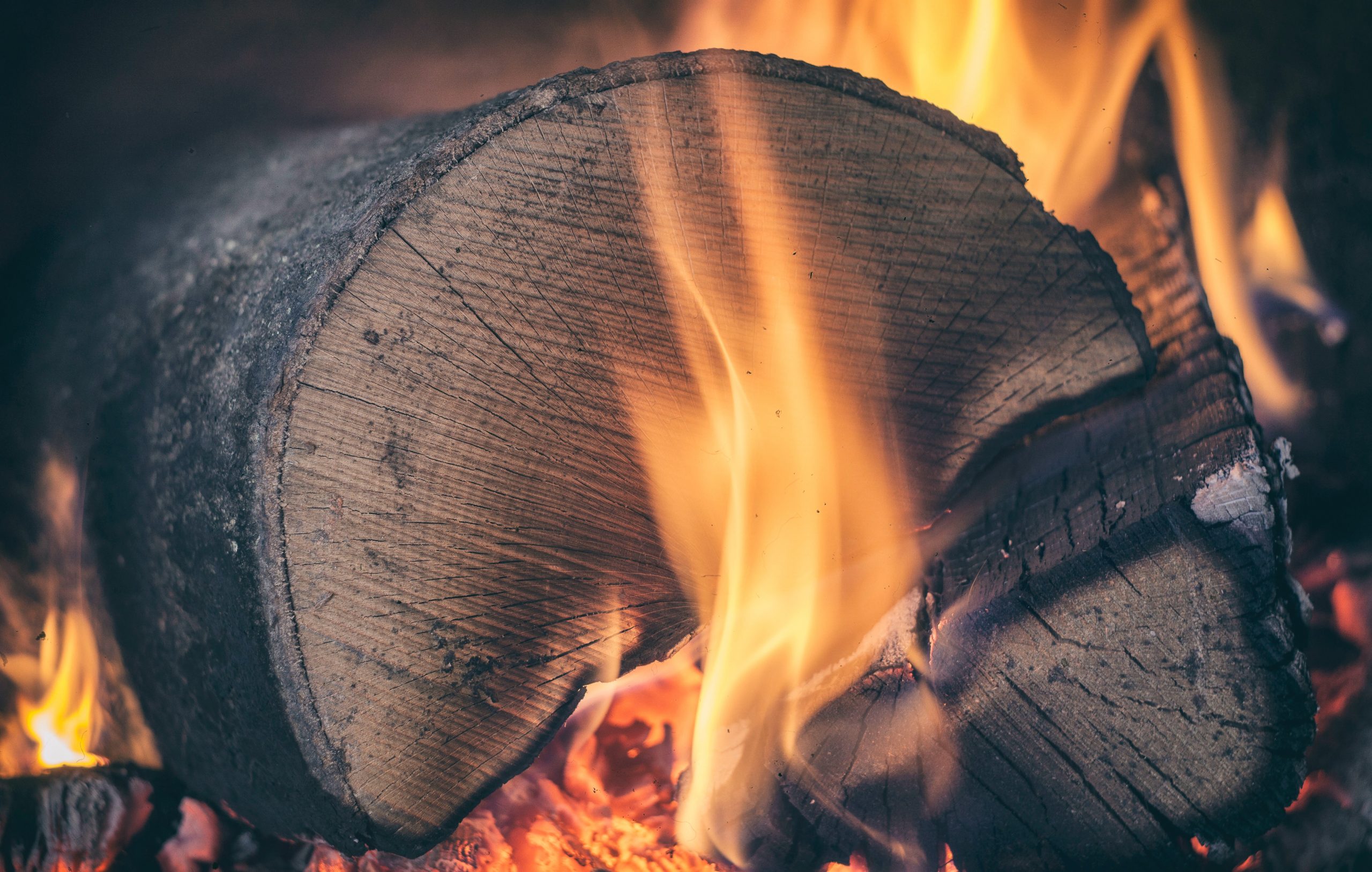 Brennendes Holzstück mit lodernder Flamme.